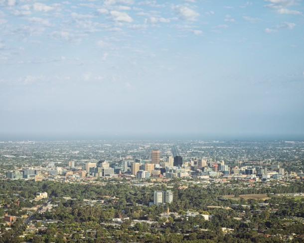 A view over South Australia's capital city, Adelaide, with suburbs in the foreground, and the sea visible beyond the central business district.